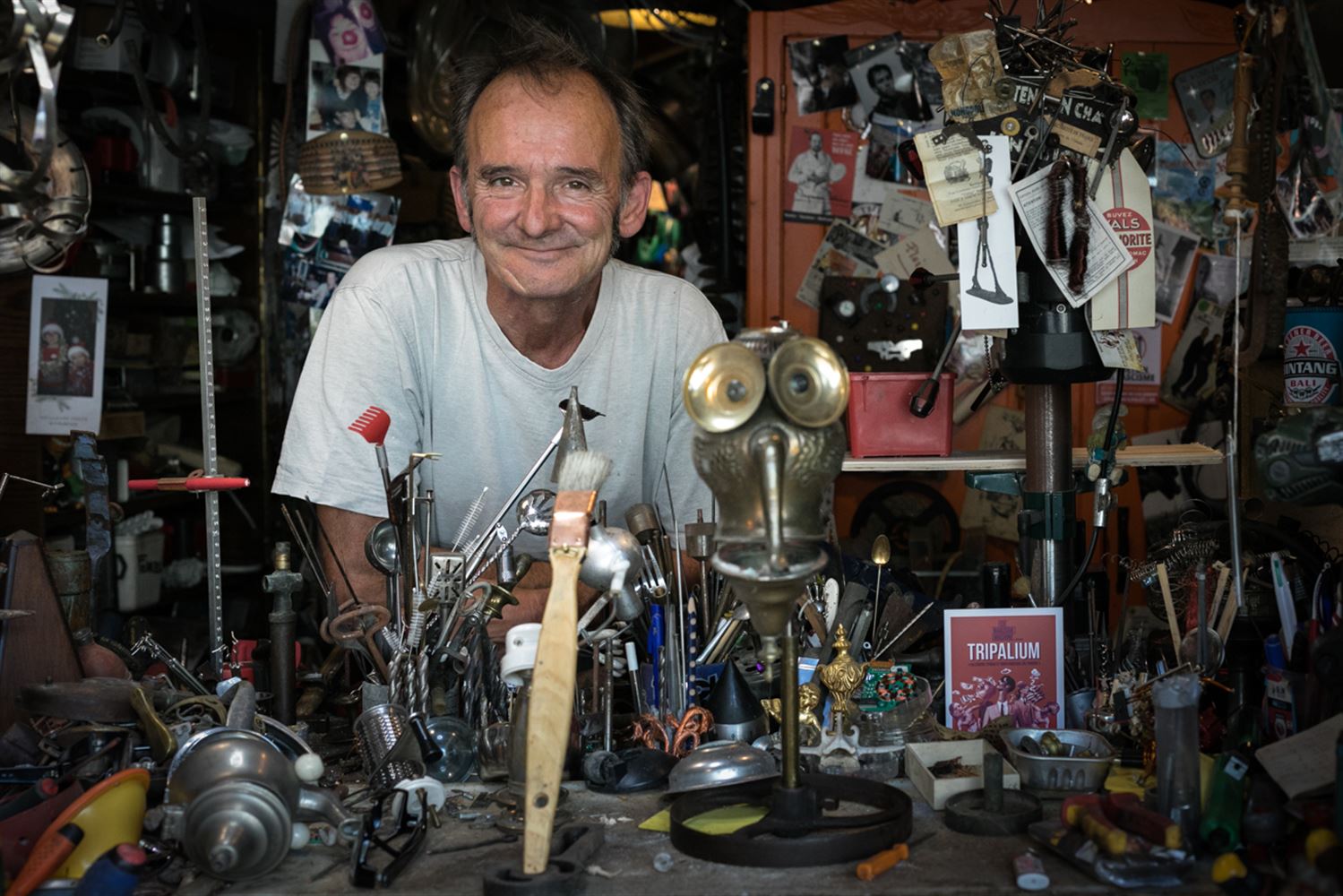 Fifi est dans son atelier, parmi mille objets hétroclites, devant lui quelques unes de ses créations artistiques