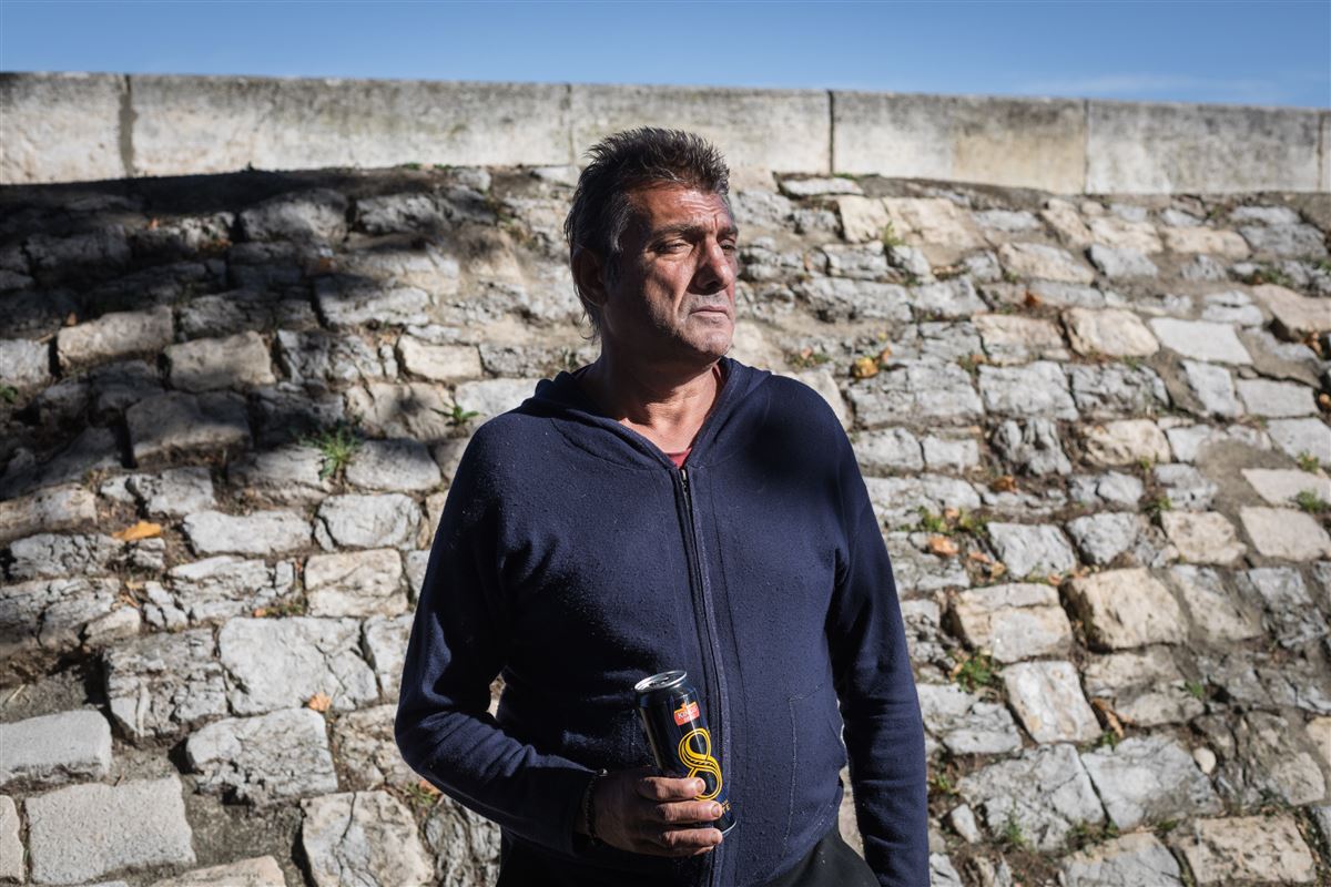 Patrick, sur les quais du Rhône à Arles, regard lointain vers sa geuche, une bière dans main droite, ambiance lumineuse, ciel très bleu
